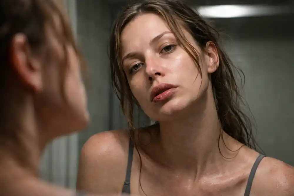 An unretouched 10K shot of a woman using the 777 manifestation morning window, showing horizontal neck lines and natural oily sheen on the T-zone.
