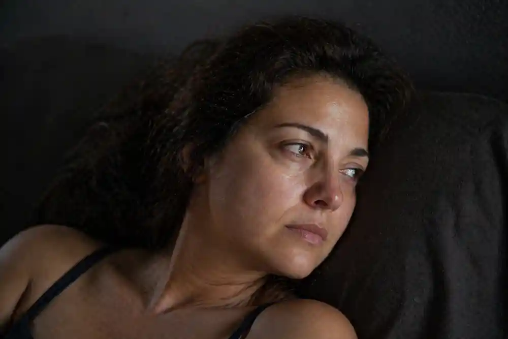 A woman resting during the May 2026 cosmic reset, highlighting the White Moon Cycle spiritual meaning and messy hair.