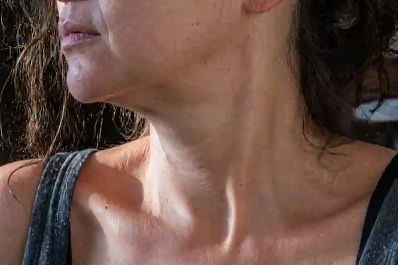 Close-up of a neck with visible tendons and tech-neck lines, reflecting biology of wealth and cortisol manifestation.