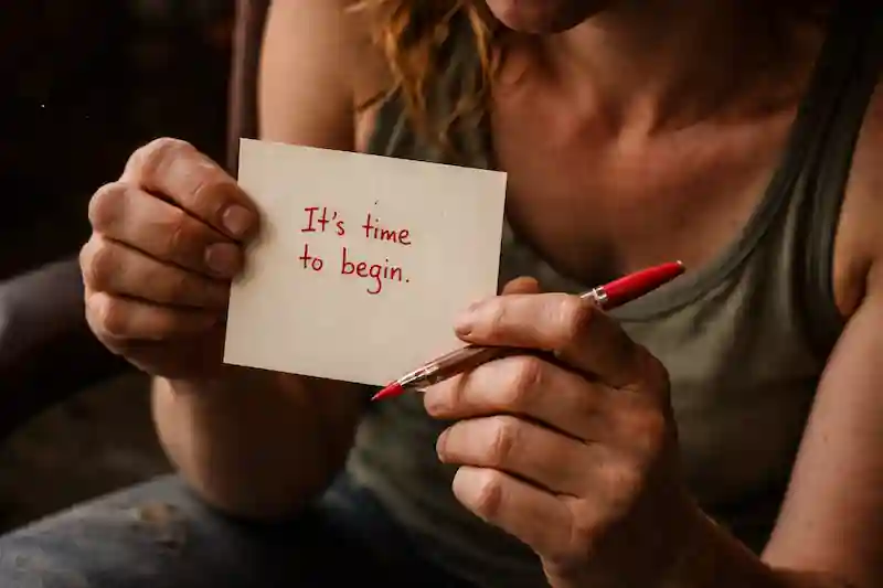 Detailed close-up of a Taurus woman's dry hands holding a square paper and red pen for 444 portal manifestation.