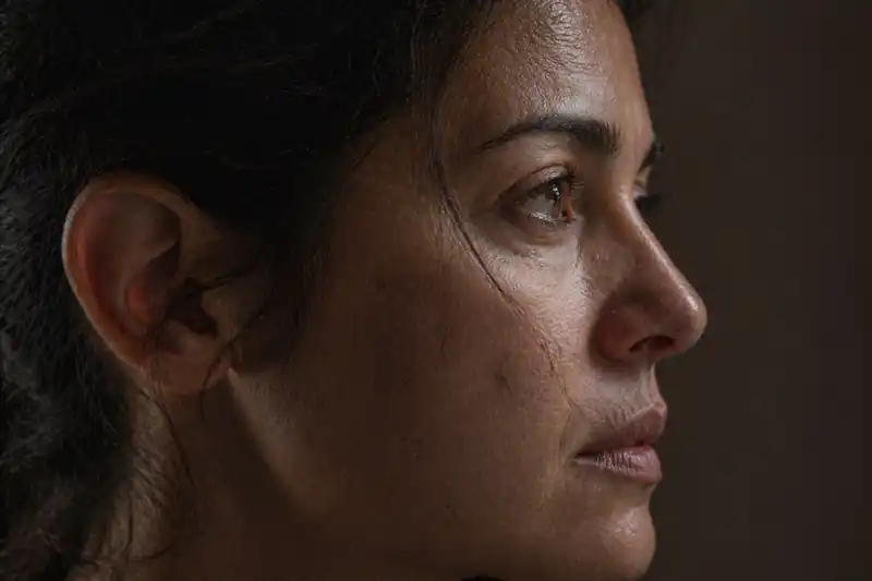 Close-up of a woman’s face with skin pores and micro-details, reflecting on starting period on New Moon for wealth manifestation