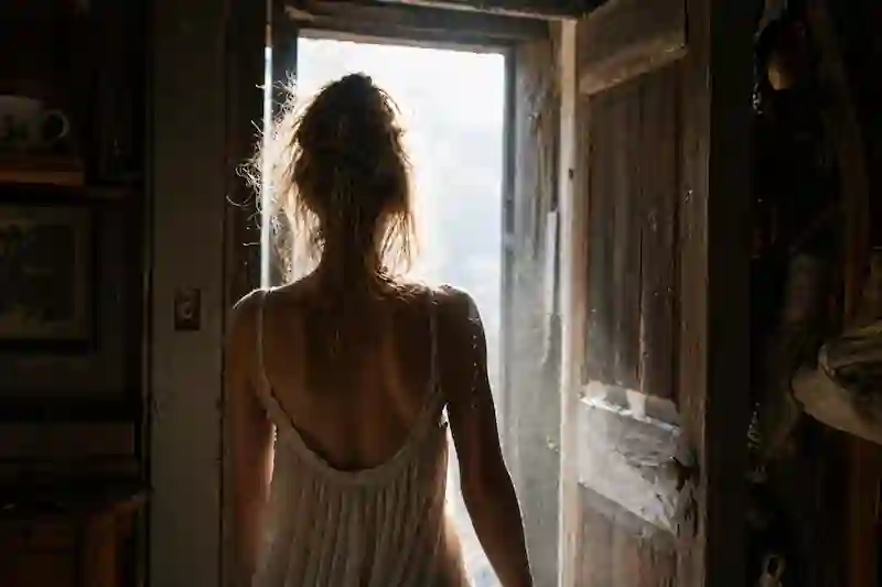 A raw, cinematic shot of a woman walking into the light, representing the final activation of the digital sigil and the waxing crescent moon emoji.