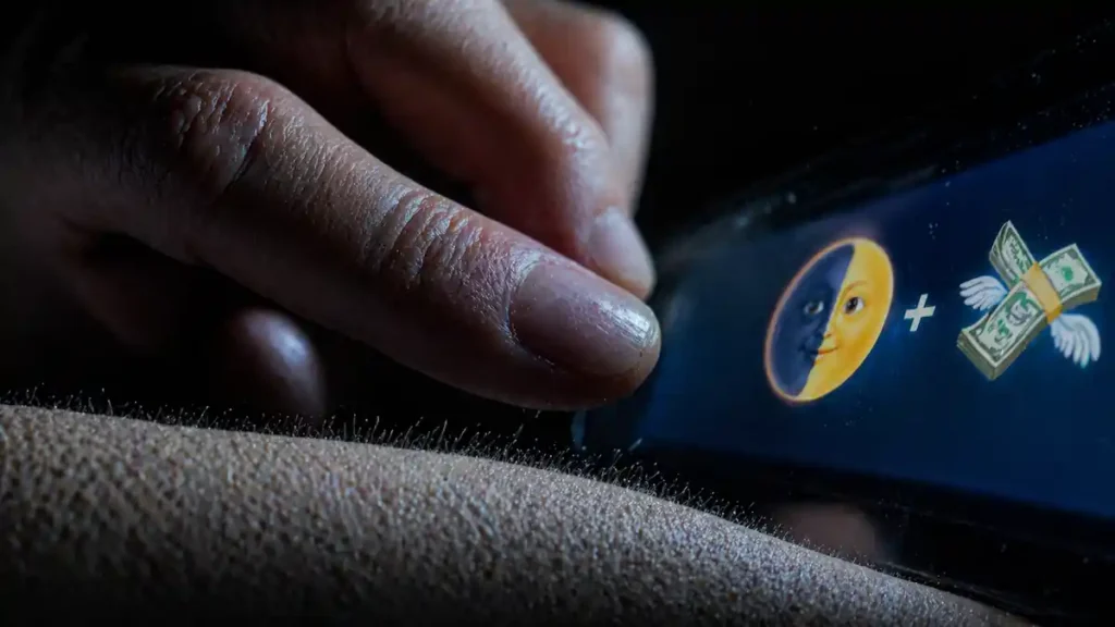 A high-detail macro photo of a womanβs hand with natural skin texture and goosebumps, holding a phone displaying a wealth manifestation code using the waxing crescent moon emoji.
